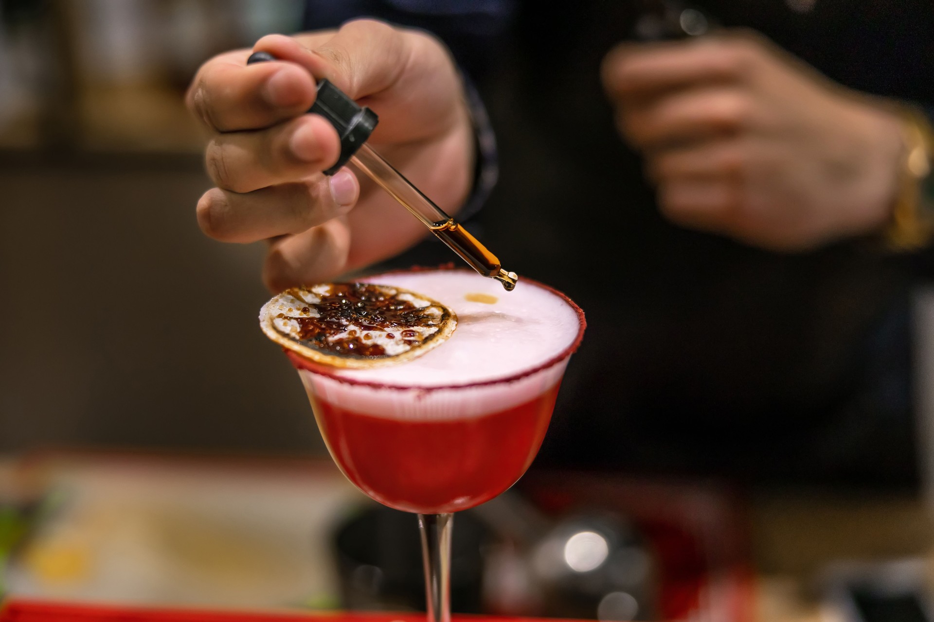 Bartender crafting a gourmet cocktail with precision and style
